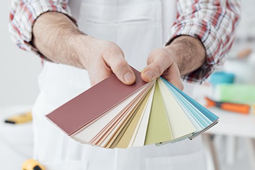 Professional painter showing a set of color swatches, home decoration and renovation concept